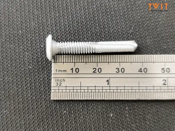Vít bắn sàn thép đầu bằng Sheh Fung mạ kẽm đặt cạnh thước đo chiều dài