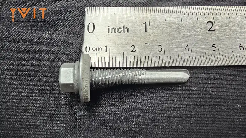 Vít tự khoan ren đơn có đệm cao su đặt dọc thước thép để đối chiếu kích thước thực tế