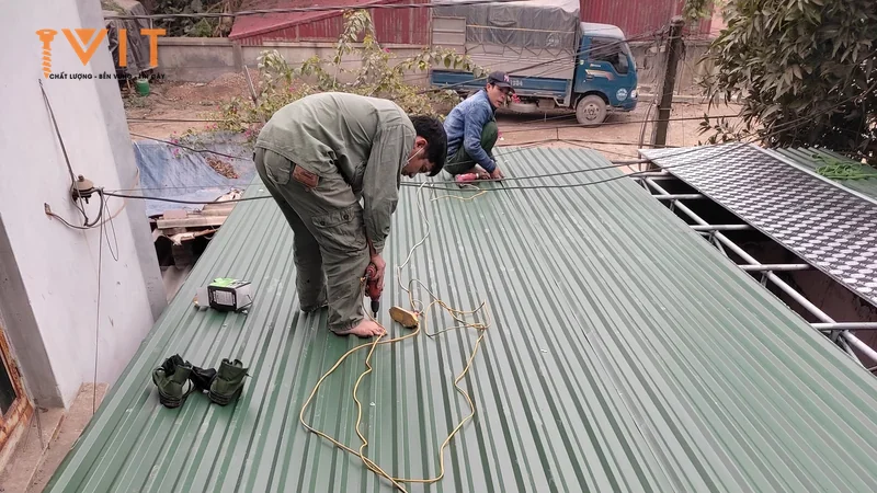 Thợ thi công đứng trên mái tôn sóng xanh đang lợp