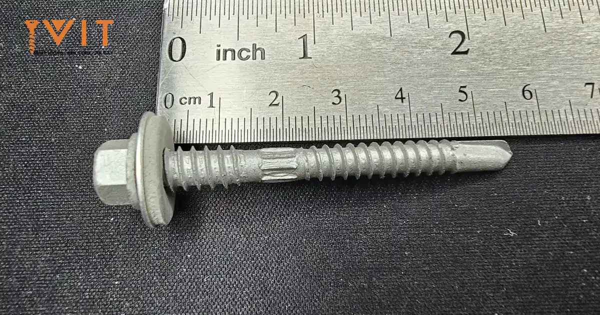 Vít bắn tôn ren kép Sheh Fung đầu lục giác kèm long đệm cao su EPDM, đặt cạnh thước đo inch và cm